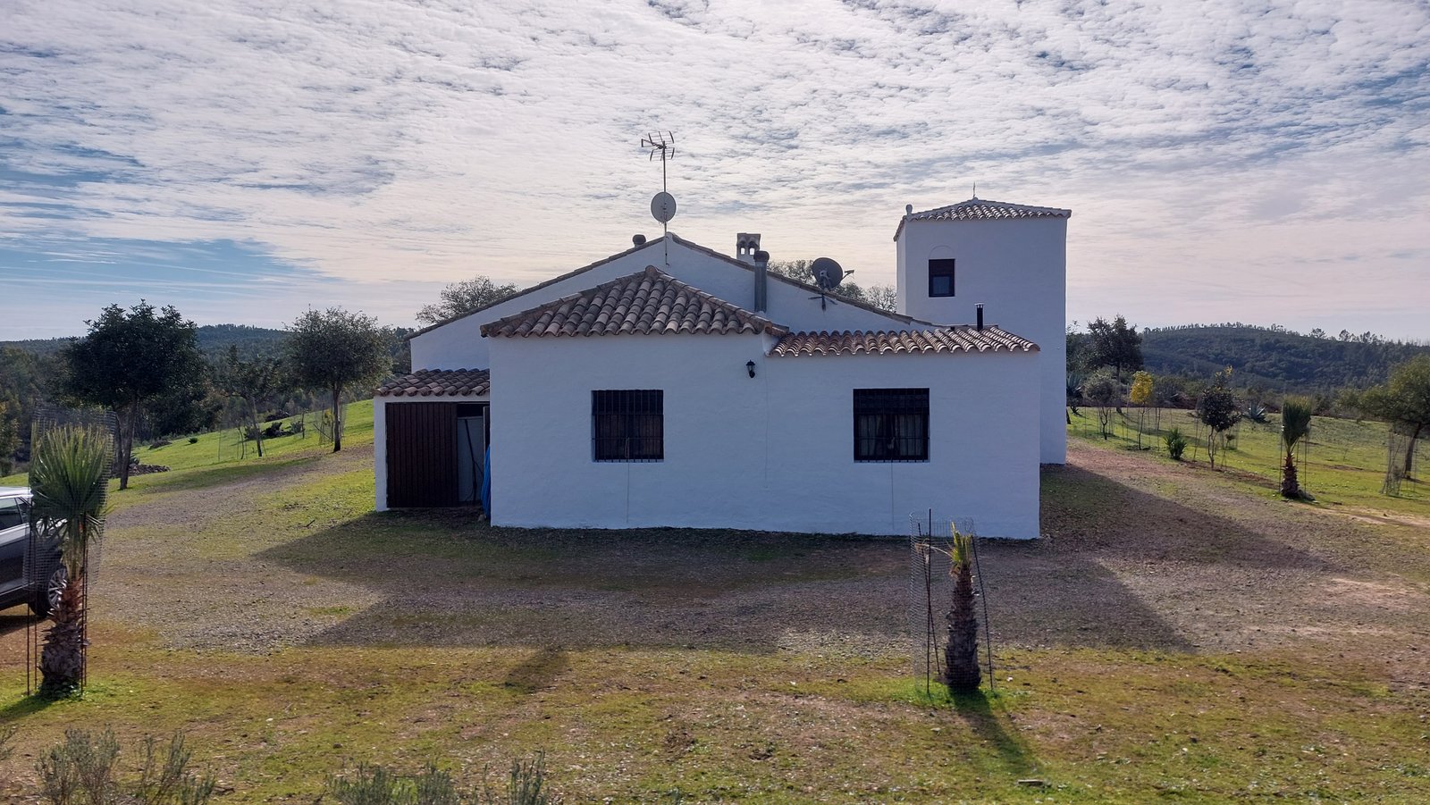 Vista lateral del cortijo con teja árabe y entorno rural