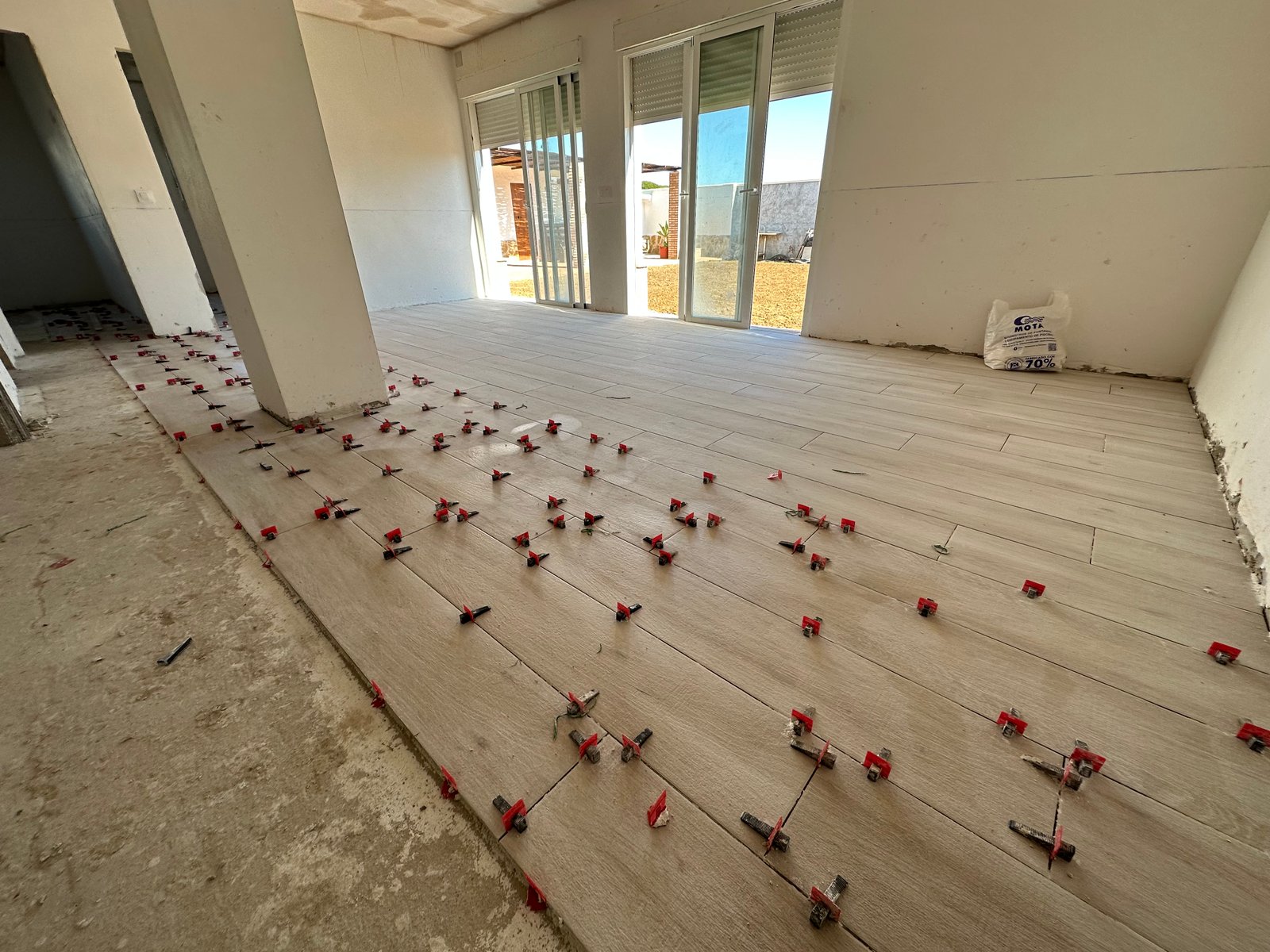 Pavimento porcelánico durante la colocación con crucetas niveladoras.
