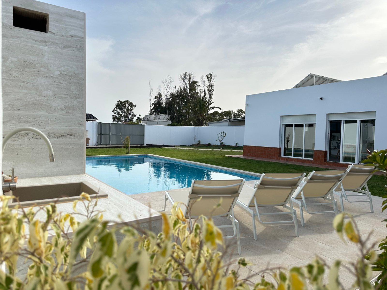 Piscina terminada con zona de descanso y ducha exterior