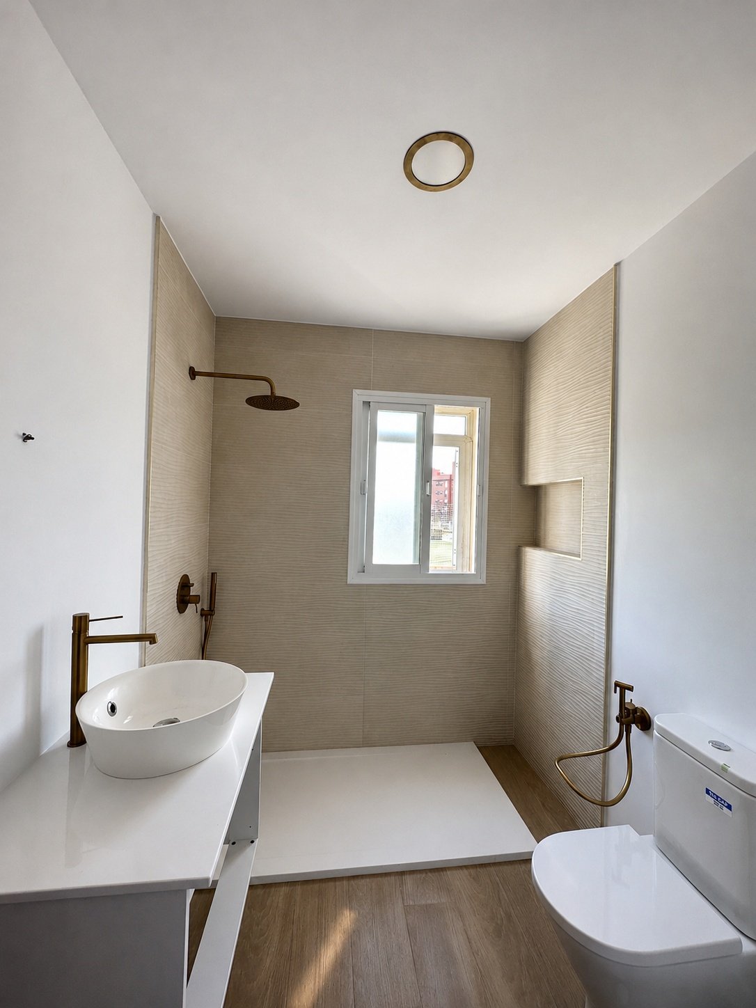 Baño suite con plato de ducha y grifería dorada