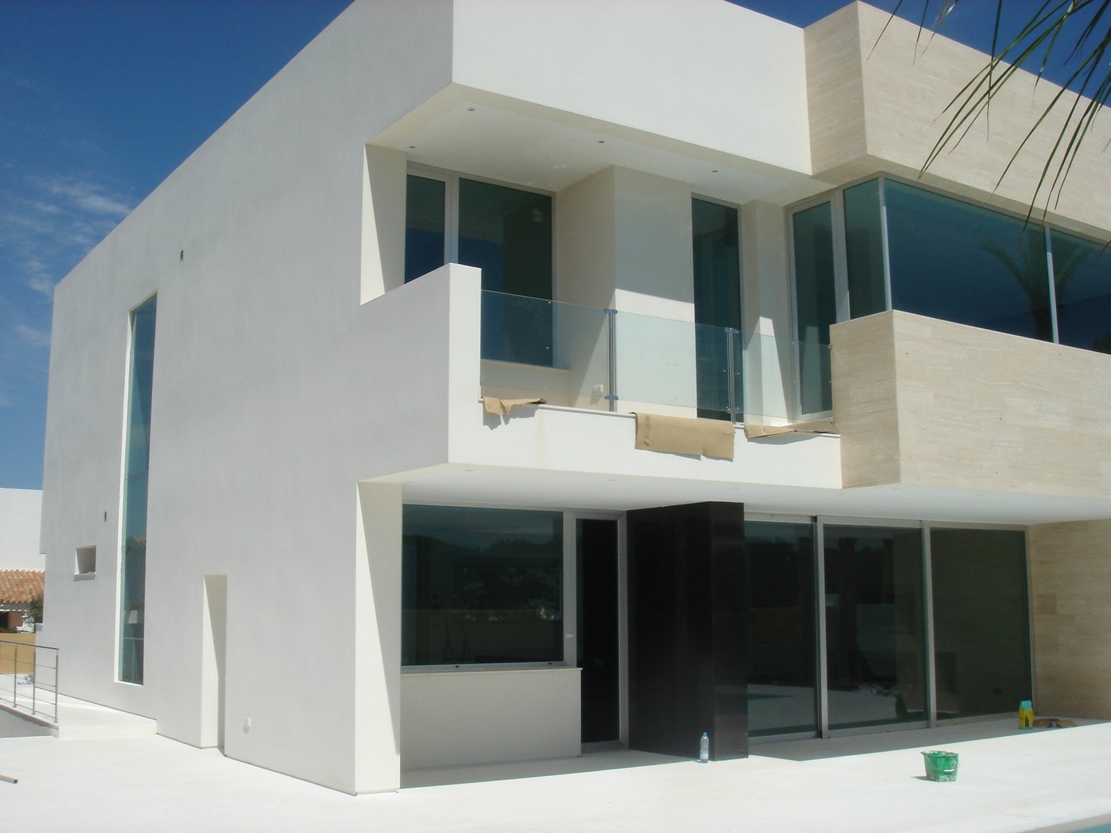 Vista lateral del chalet con balcón y grandes acristalamientos