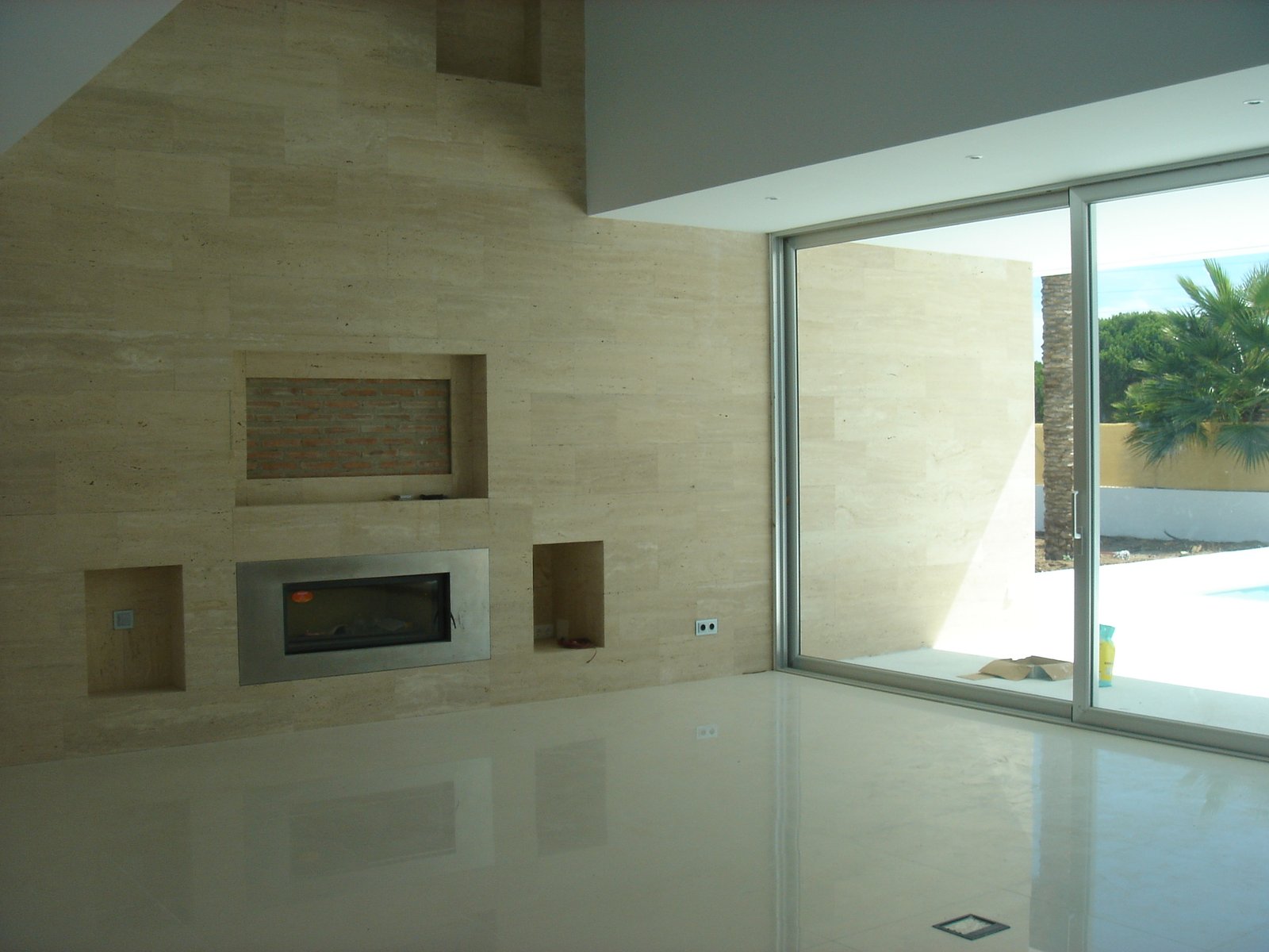 Salón interior con chimenea integrada en pared de travertino